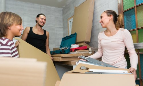 Furniture pick-up team loading a sofa from a Maidavale home