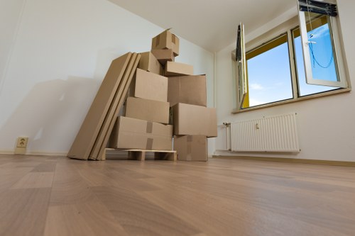 Local furniture removal crew carrying a wardrobe from a residential property